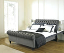 grey plush sleigh bed frame with matching buttons and wooden legs feet